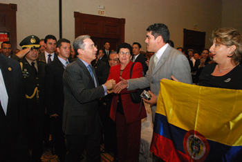 El Presidente Álvaro Uribe a su llegada, este jueves en la noche, al Encuentro Nacional de la Empresa Privada (Enade), que se realiza en San Salvador. El Mandatario colombiano saluda a los asistentes, mientras uno de ellos exhibe una bandera de Colombia.