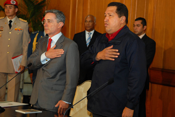 Los presidentes de Colombia, Álvaro Uribe, y de Venezuela, Hugo Chávez, escuchan las notas del himno del vecino país, al inicio de la rueda de prensa en el Palacio de Miraflores, luego de la reunión que tuvieron ambos mandatarios en la ciudad de Caracas, con el fin de revisar temas comerciales y económicos.