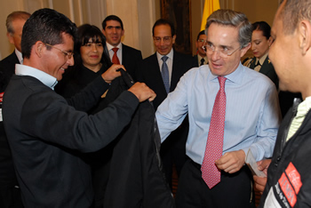 El Presidente Uribe se dispone a vestir la chaqueta que confecciona una microempresa de reinsertados, que hace parte del programa Banco de Tiempo, liderado por la Empresa Coca Cola Femsa. La escena se registró este miércoles en la Casa de Nariño, luego del acto de graduación de los primeros beneficiarios de este proyecto.