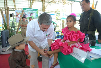 El Presidente Álvaro Uribe Vélez le ajusta la zapatilla de baile a la niña Laura Jimena Cubillos, quien ejecutó una pieza del tradicional joropo con el grupo Academia Cabrestero, durante el Consejo Comunal de Gobierno que el Mandatario instaló este sábado, 7 de febrero, en Villavicencio.