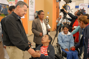 El Presidente Álvaro Uribe Vélez saluda a las señoras María de Jesús Callejas y María Adelina López de Becerra, discapacitadas de Tunja, quienes recibieron este sábado 14 de febrero unos audífonos entregados por el programa ‘Volver’, del Ministerio de la Protección Social. Este proyecto es administrado por el Consorcio Prosperar en el departamento de Boyacá.