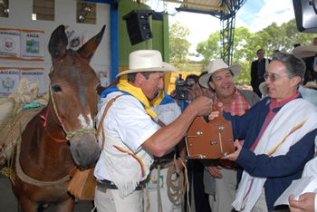 Un arriero le obsequia una ‘carrasca’ al Presidente Álvaro Uribe, durante el Consejo Comunal celebrado este sábado en Urrao, Antioquia. Se trata de un artefacto autóctono que sirve para animar las mulas durante los viajes de arriería.