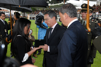 El Presidente Álvaro Uribe entrega a la esposa del patrullero John Alexander Pinilla, Johana Lisbeth Alfonso Torres, la medalla que asciende en forma póstuma al suboficial fallecido hace pocos días en una operación antiterrorista en el Caquetá. Lo acompañó el Ministro de Defensa, Gabriel Silva, durante la celebración de los 118 años de la Policía, efectuada este jueves en la Escuela de Cadetes 'General Francisco de Paula Santander'. 