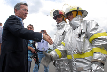 El Presidente Álvaro Uribe saluda a dos integrantes del cuerpo de bomberos de Armenia, que cuentan desde este sábado con una nueva maquina de extinción de incendios para el Aeropuerto Internacional El Edén, de esta ciudad.